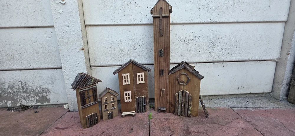 A group of miniature handmade houses with varied rooflines and windows.