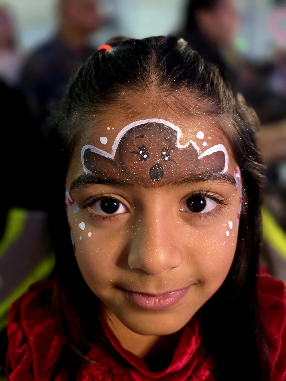 A glittering decorative forehead design with white dots and a central jewel.