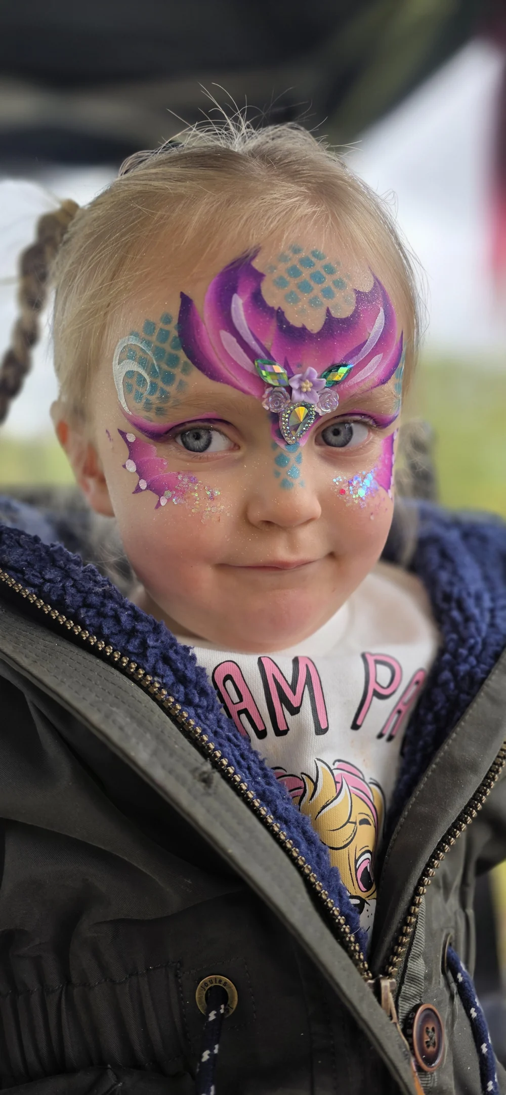 A purple and turquoise forehead design with white highlights.