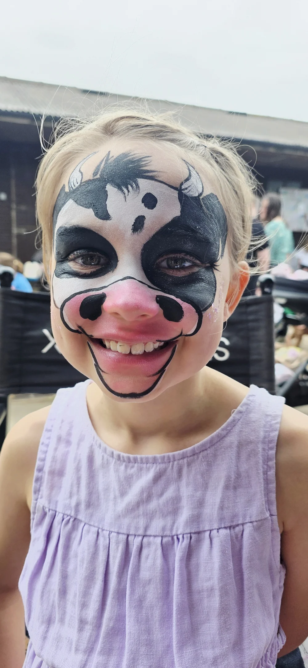 Black and white animal face painting with a pink nose.
