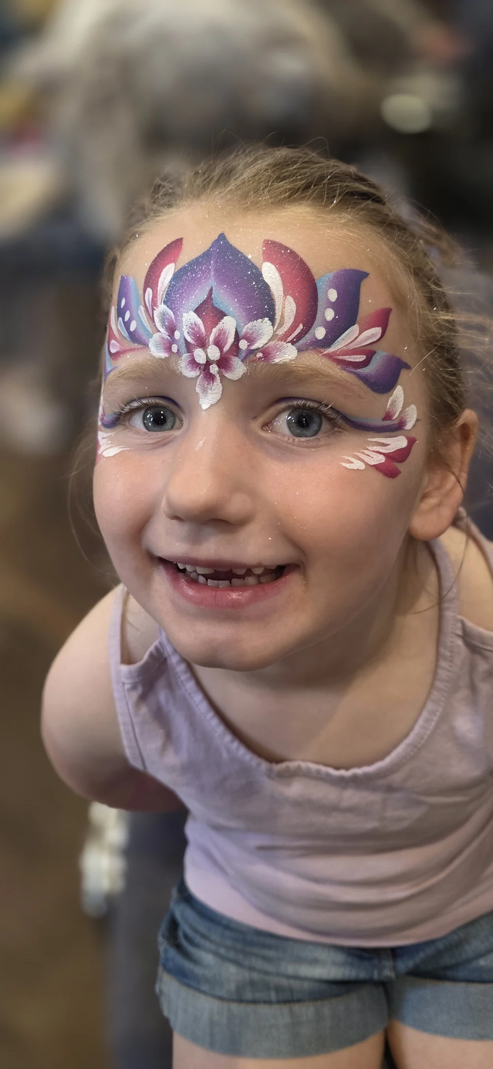 A purple and pink forehead design with fine white flourishes.