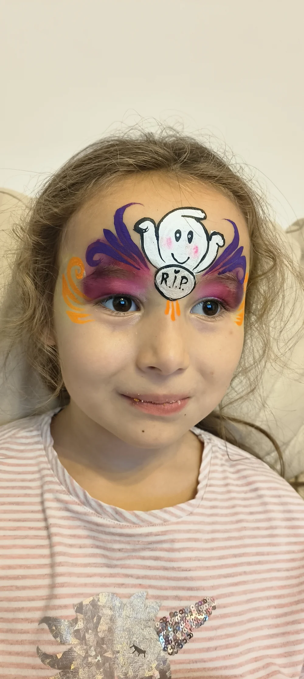 A playful cartoon eye design painted across the forehead.