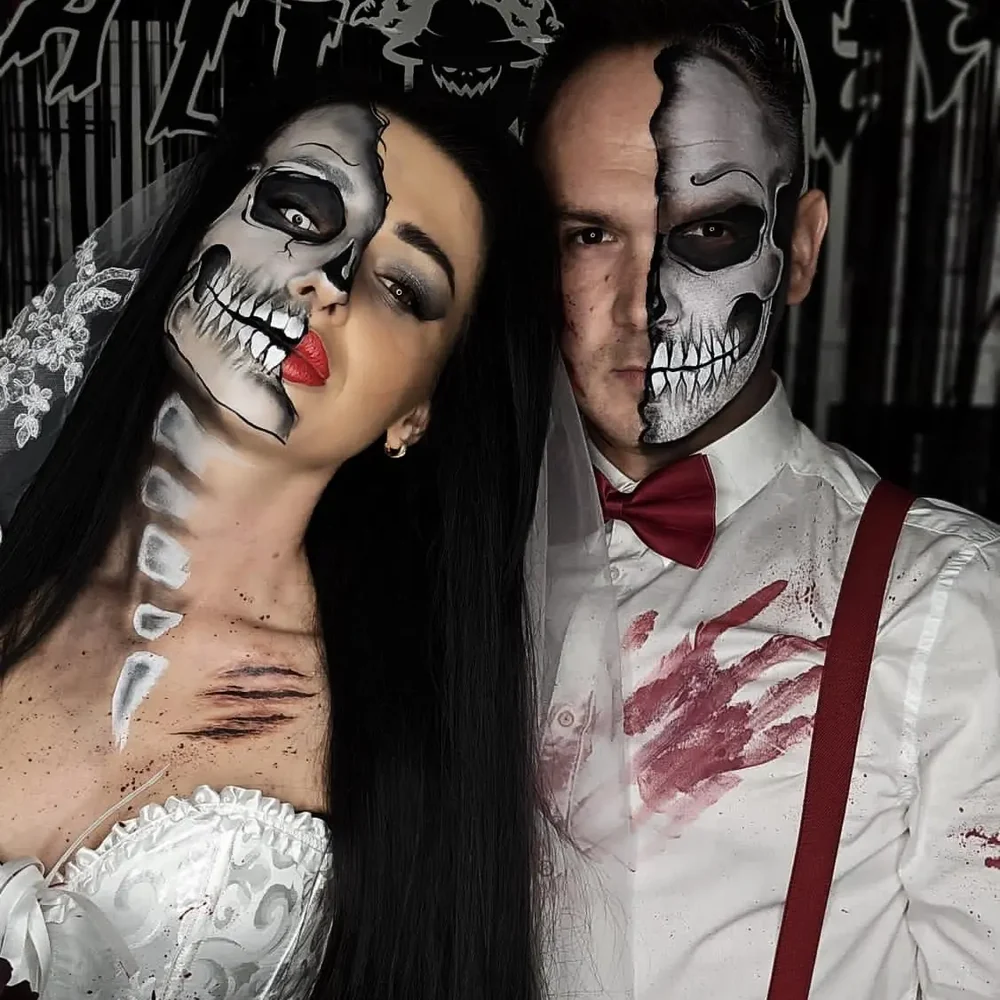 A couple wearing detailed half-skeleton Halloween face painting; both faces are shown in full.