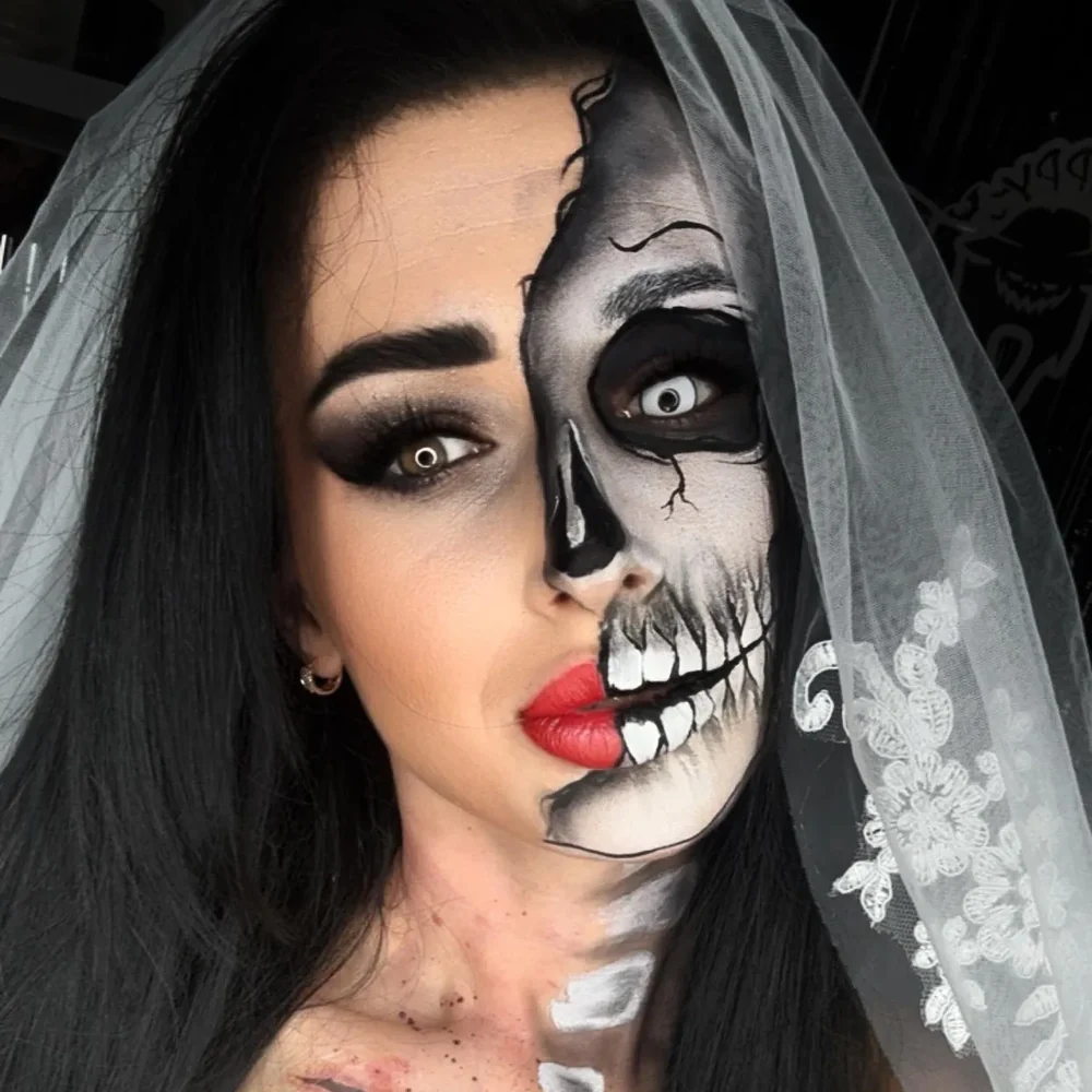 A portrait showing half-skull face painting and red lips.